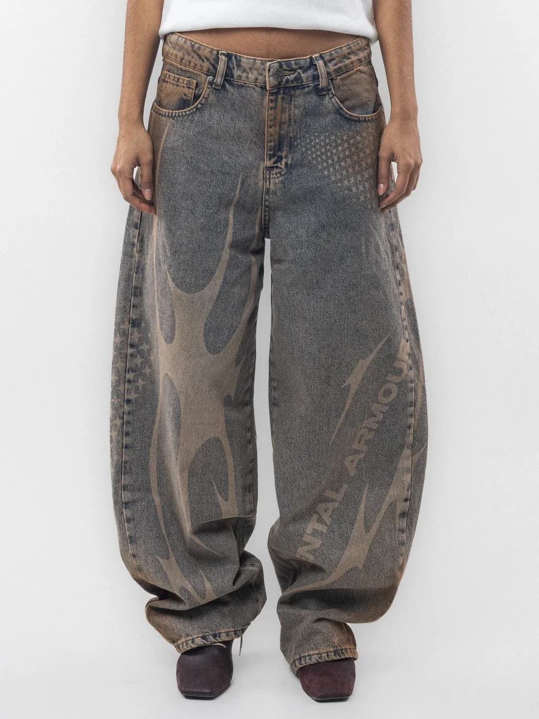 Front view of grey wide leg jeans with pale curved graphics and lettering
