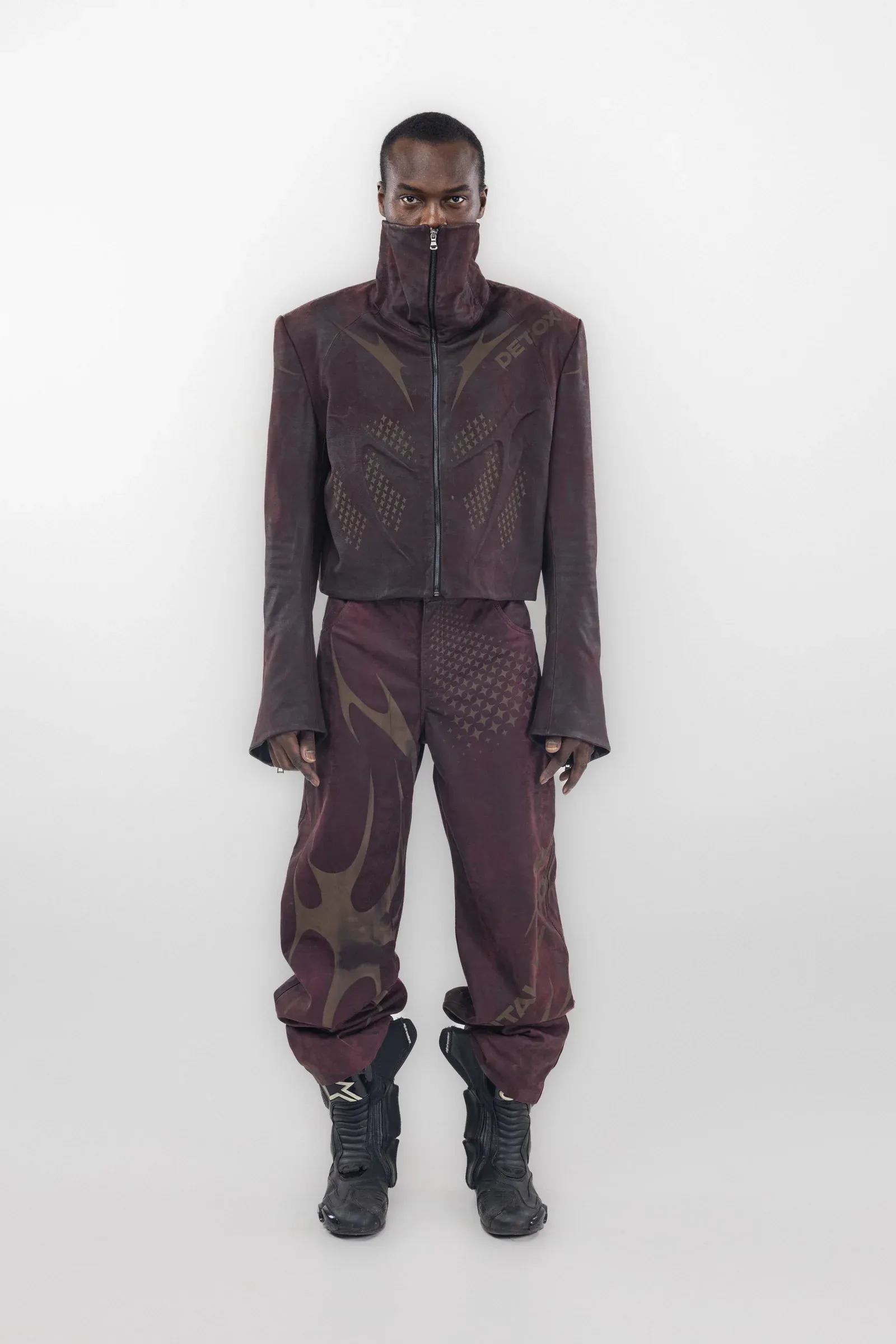 Front view of a burgundy cropped jacket and trousers with tonal curved graphics