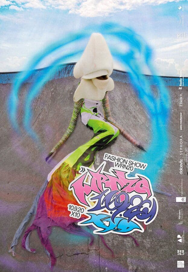 Model in bright green clothing beneath a white sculptural headpiece and blue ring
