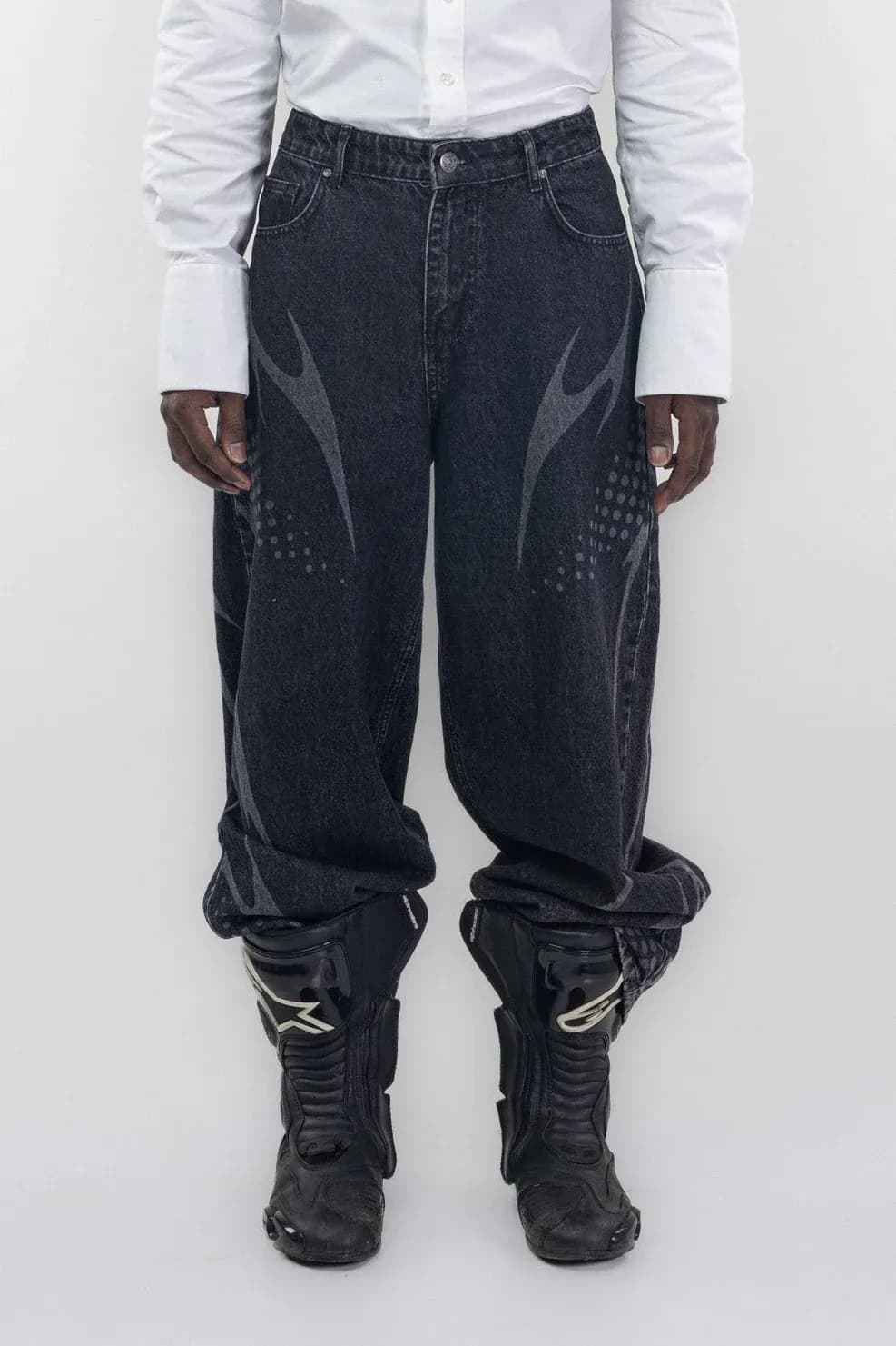 Dark wide leg jeans with pale flame shaped graphics, worn with a white shirt