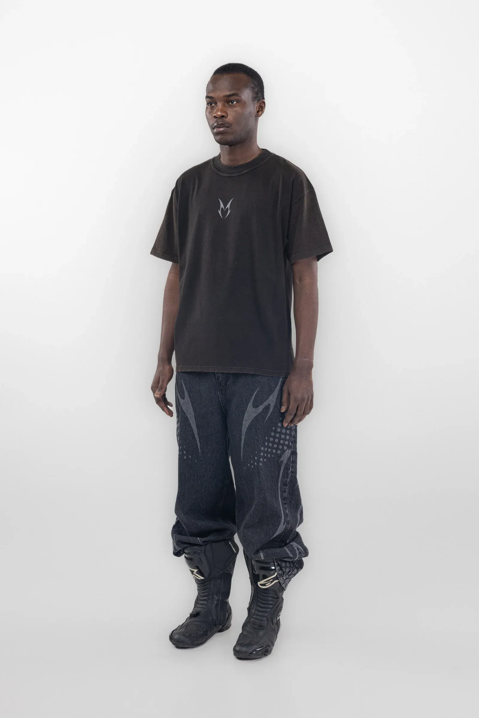 Full length view of a black T shirt and dark jeans with pale leg graphics