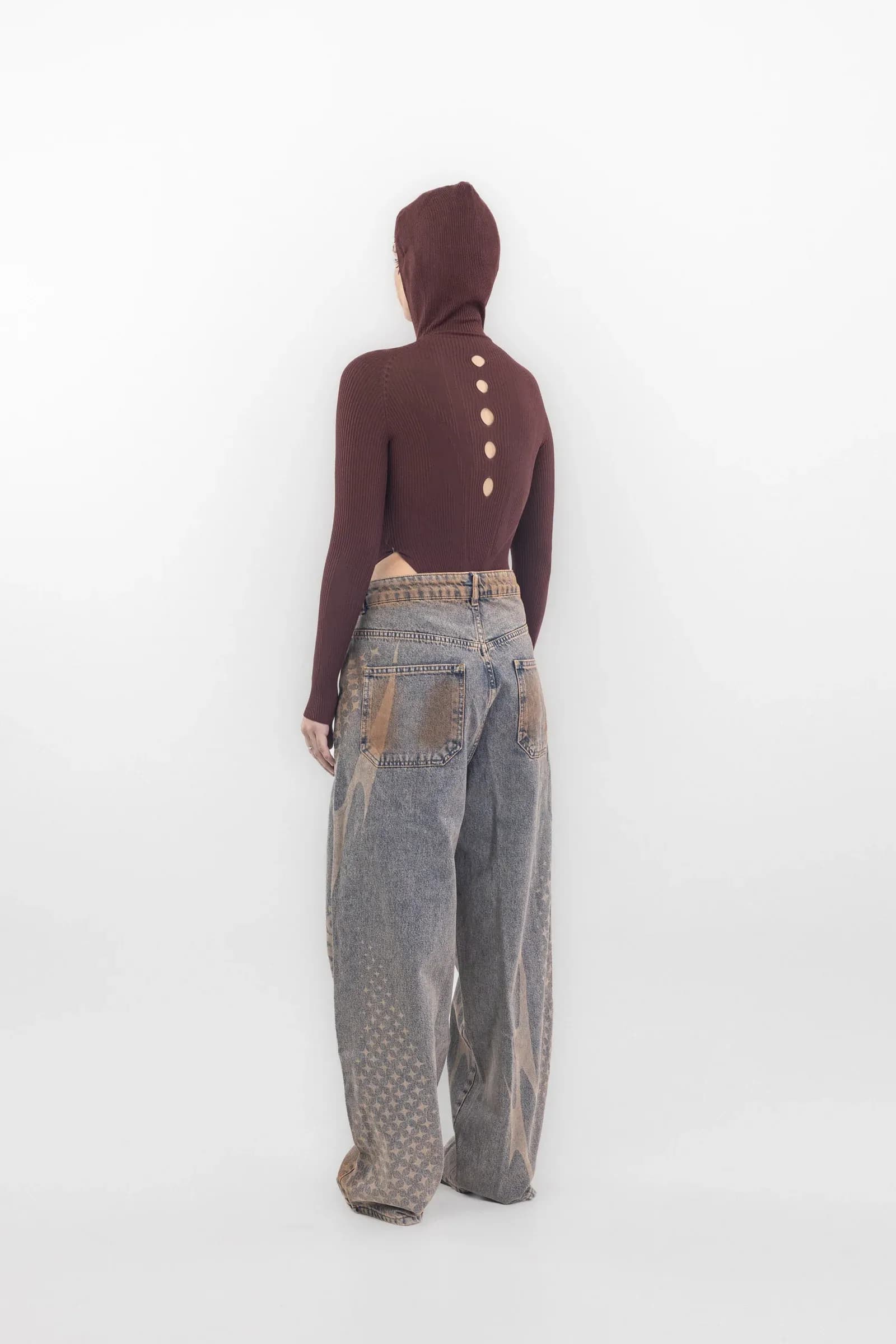 Rear of a burgundy hooded bodysuit with circular openings along the spine