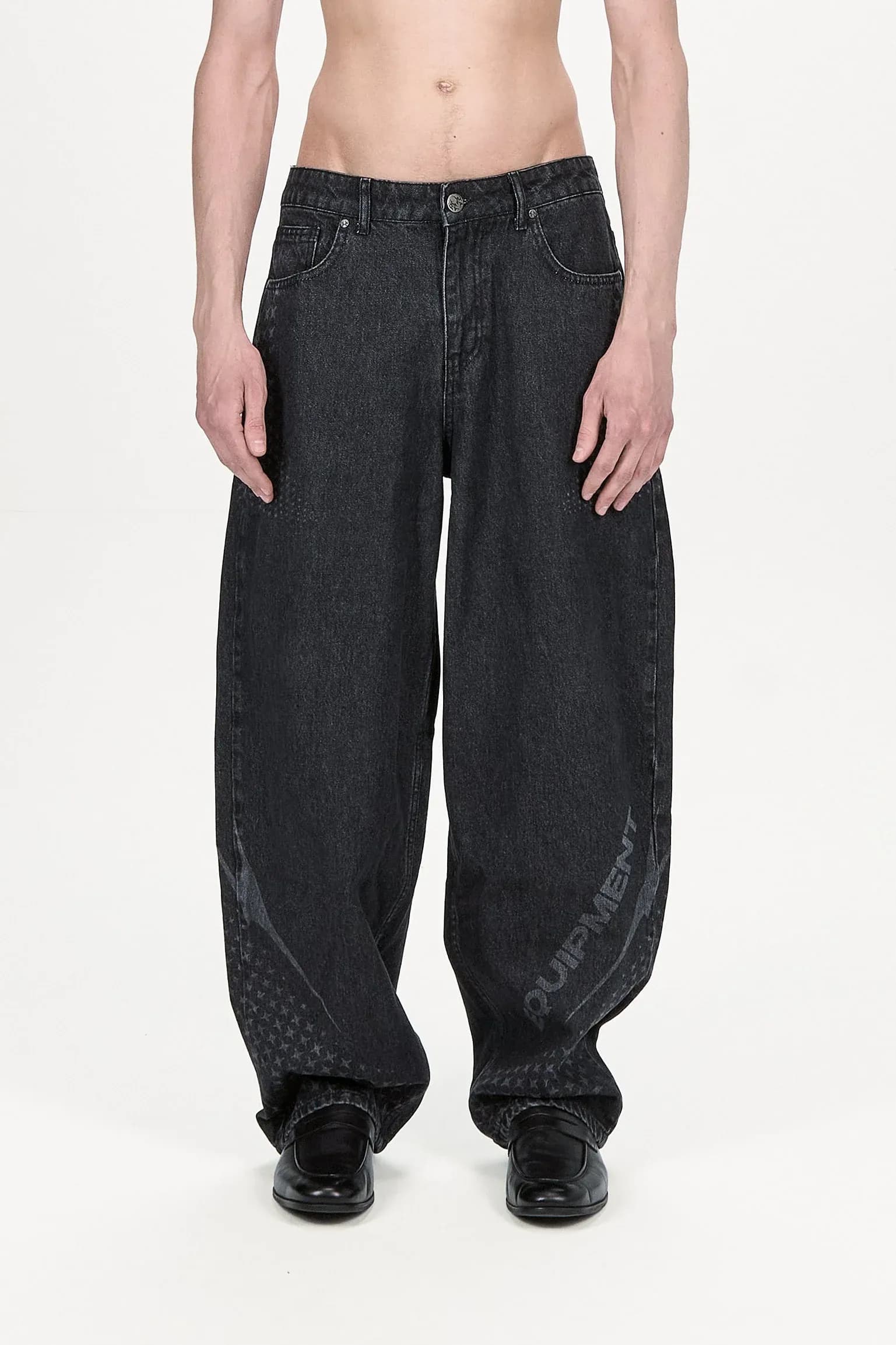 Front view of dark wide leg jeans with pale curved graphics and textured panels