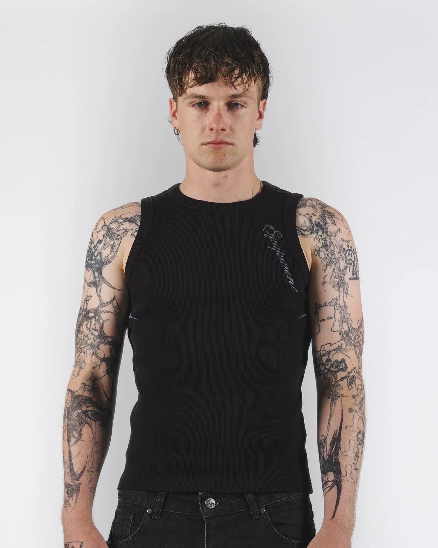 Black tank top with a small pale graphic near the shoulder