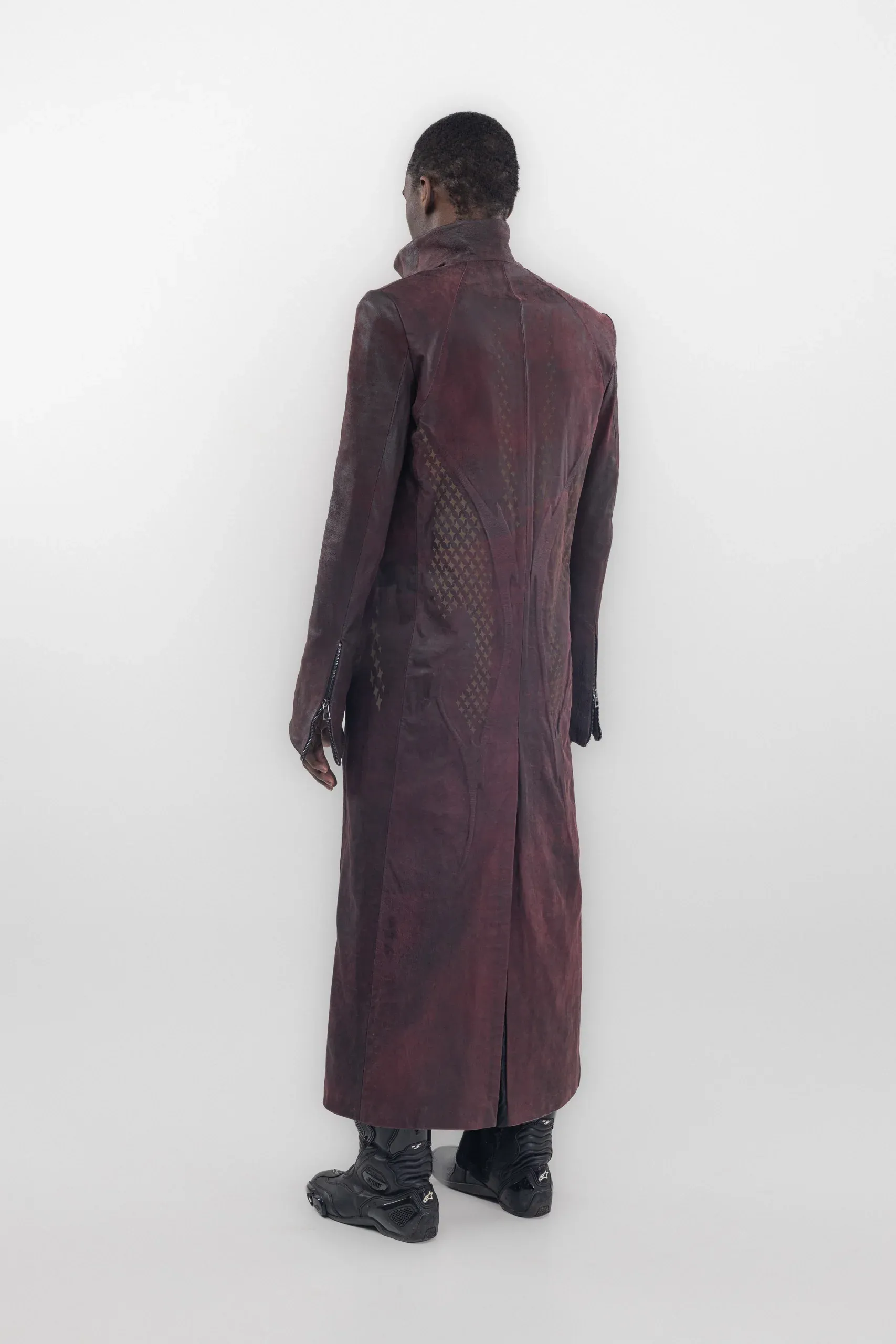 Rear view of a long burgundy coat with dark curved graphics