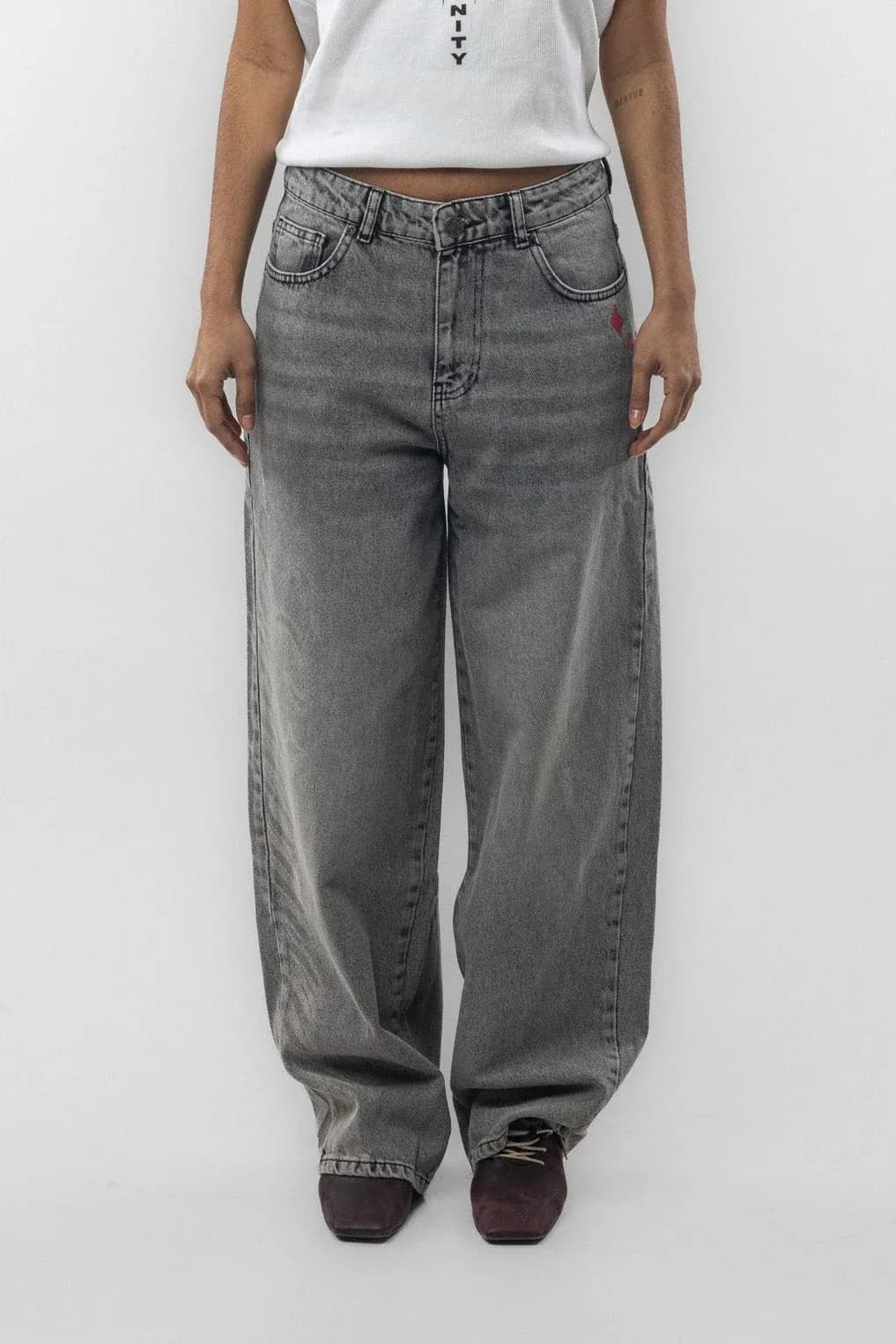 Front view of grey jeans worn with a white cropped top
